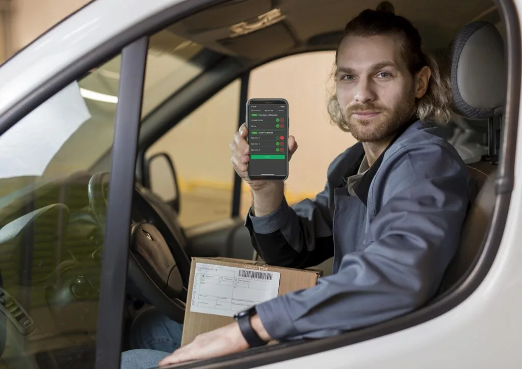 Conducteur tenant un smartphone avec l'application d'inspection véhicule Conducteur tenant un smartphone avec l'application d'inspection véhicule